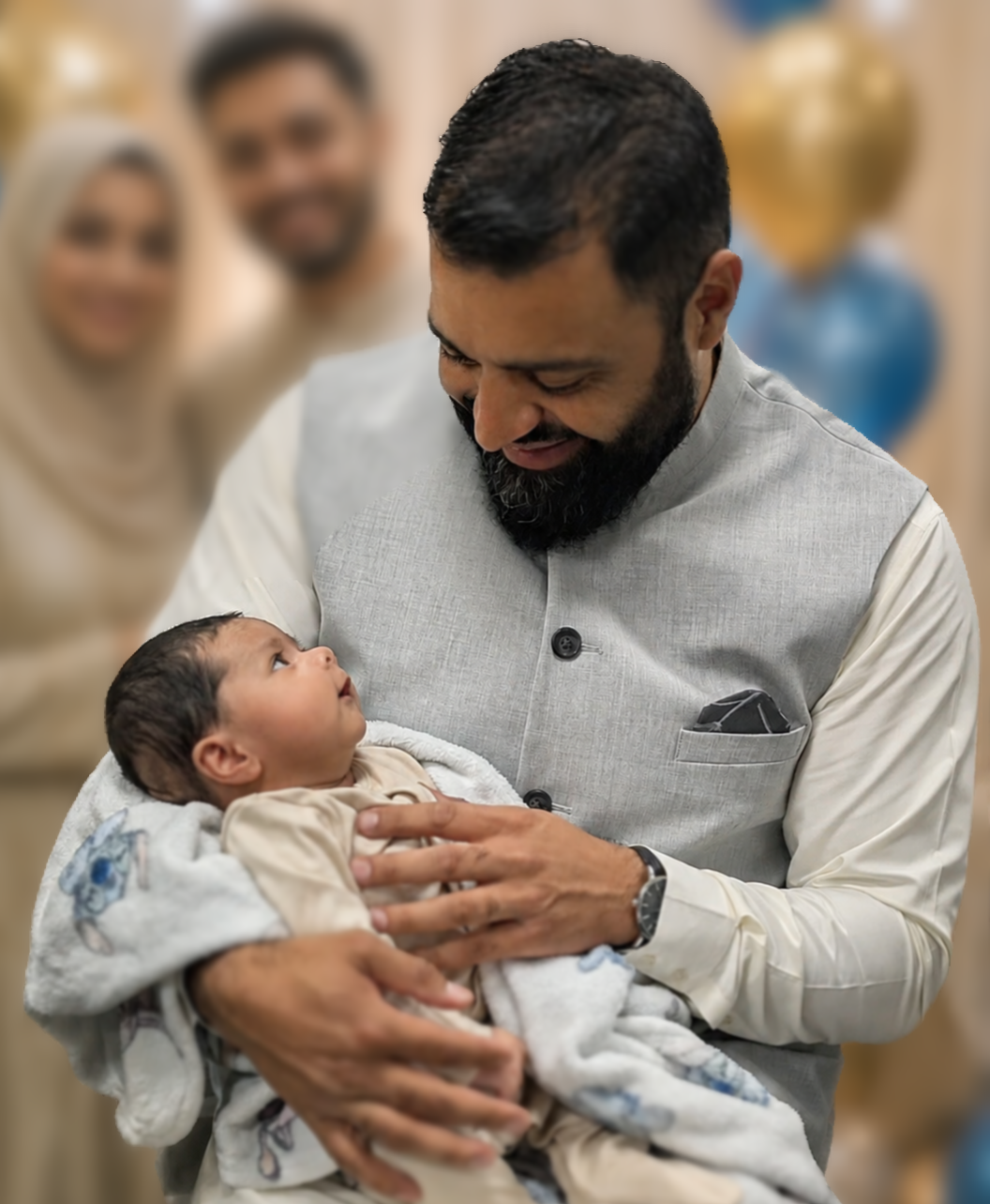 Sheikh Junaid Dar holding a newborn at an Aqeeqah ceremony